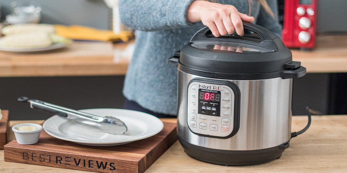 Instant Pot on countertop with hand on lid