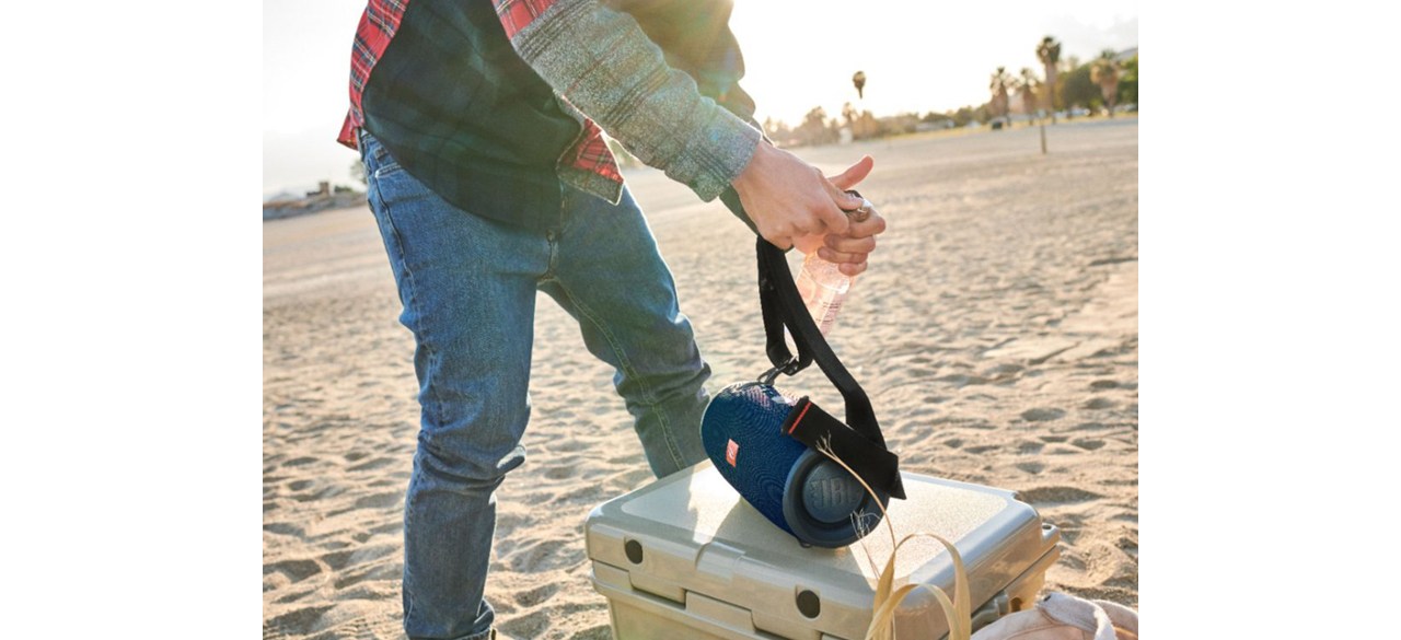 Person placing JBL Xtreme 2 Portable Bluetooth Speaker on top of cooler at the beach