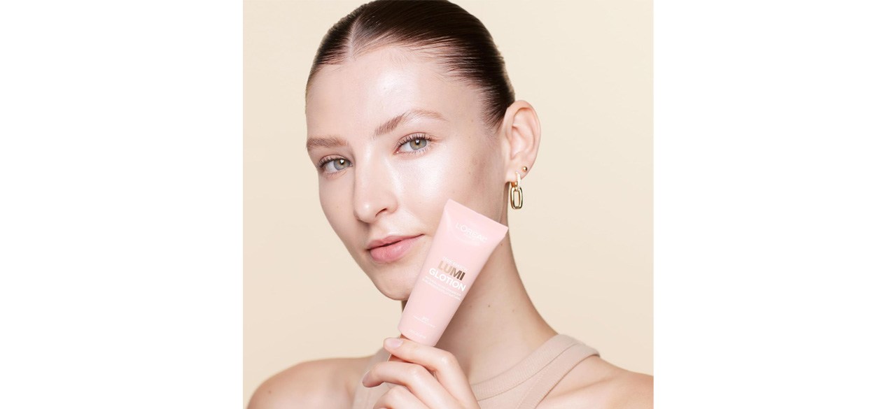 Woman holding tube of L’Oréal Paris Makeup True Match Lumi Glotion Natural Glow Enhancer Lotion