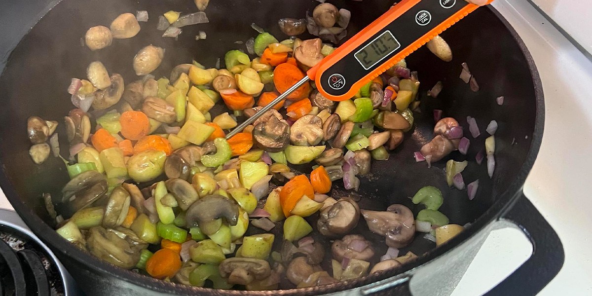 Dutch oven with vegetables and thermometer inside