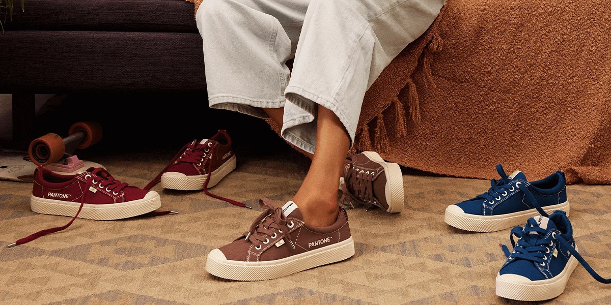 Person wearing Pantone brown sneakers sitting on sofa