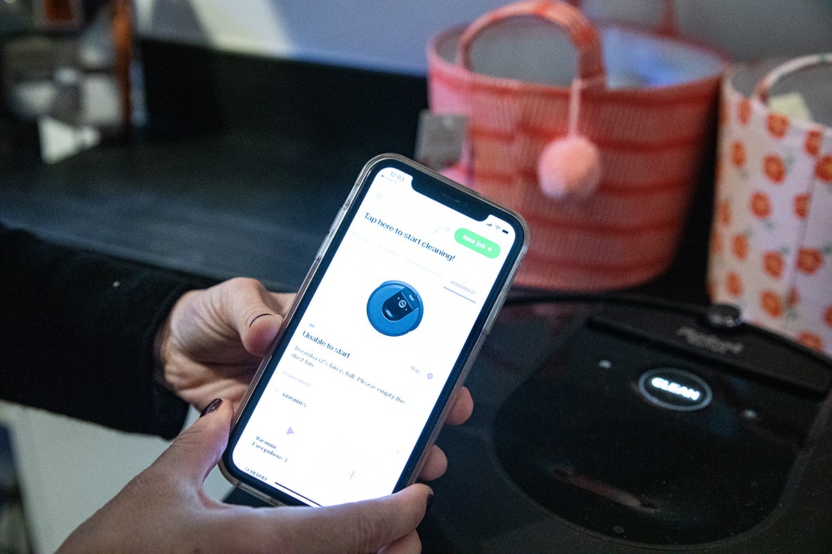 Person using iRobot app to navigate iRobot Roomba i7