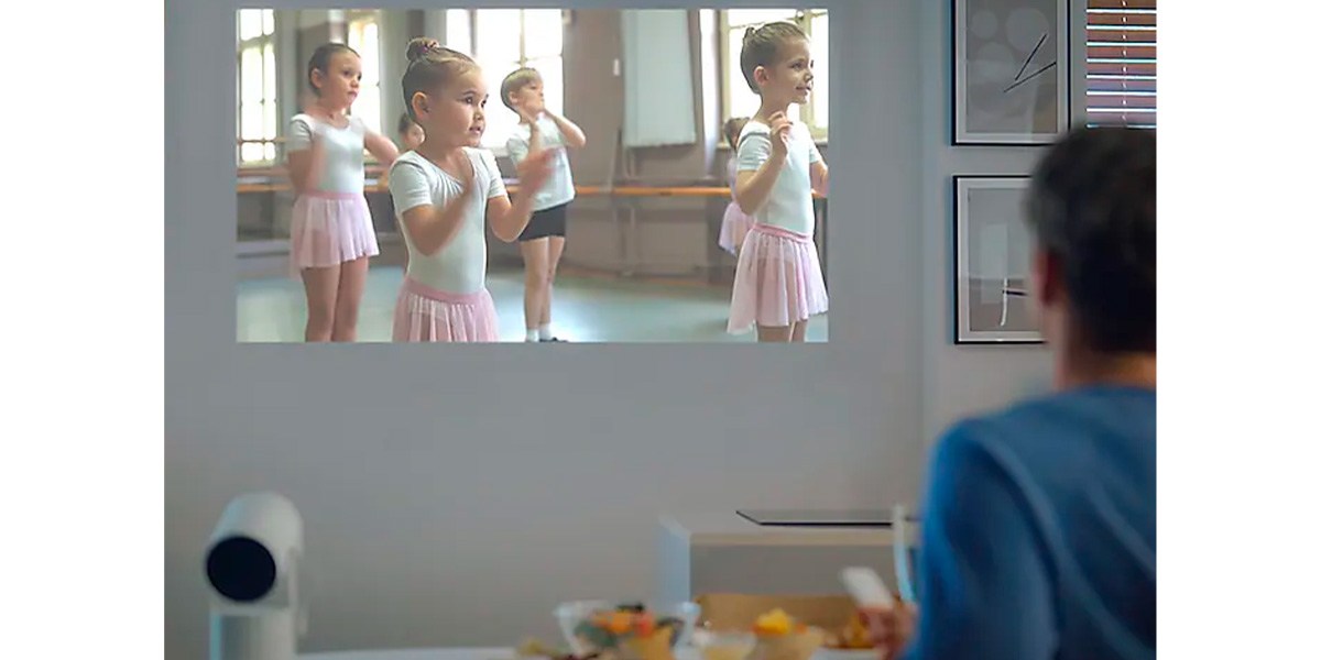 A person watching a kids ballet class on a projected image on a wall