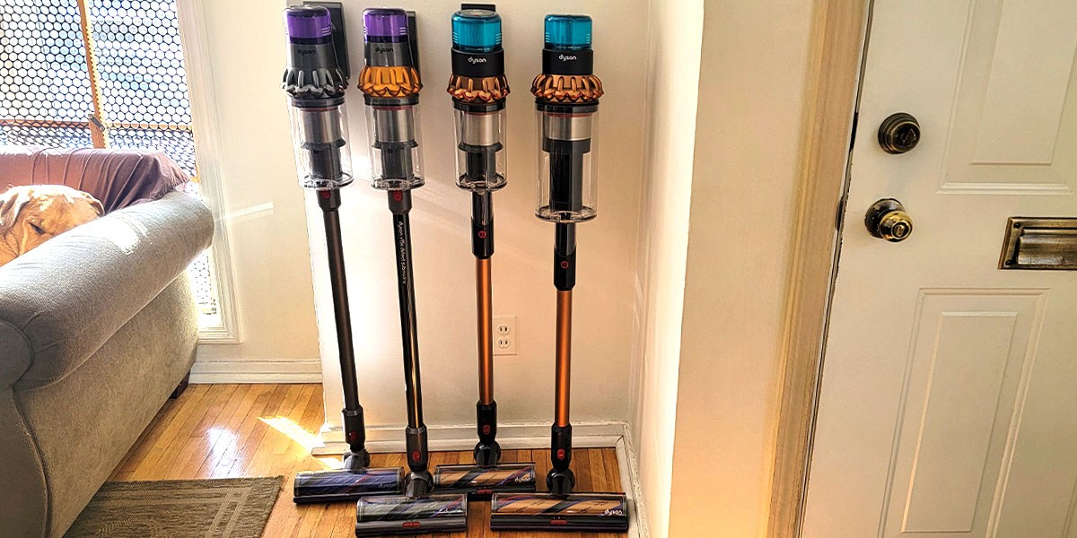 Four Dyson vacuums leaning against wall