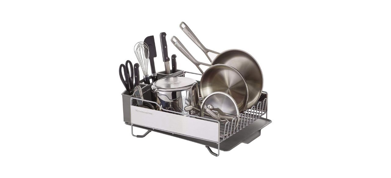 A full-size dish rack with dishes stored in it. It has a spot on the side to hold smaller utensils.