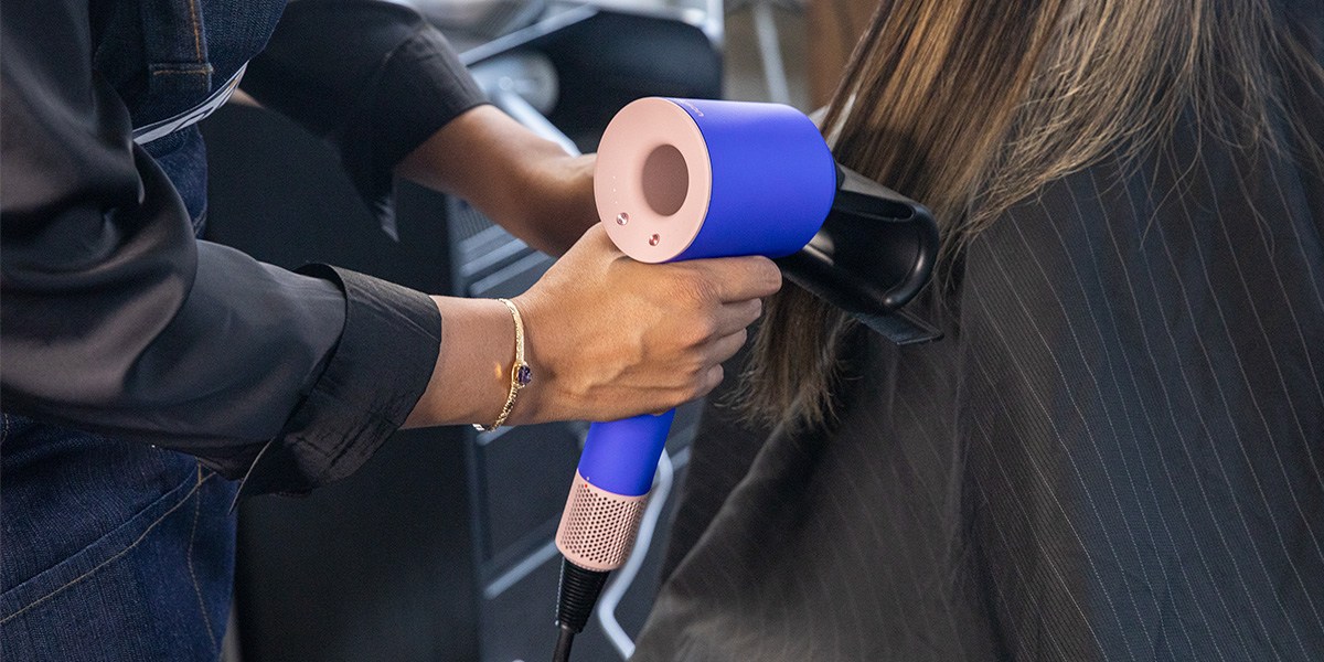 Stylist using Dyson Supersonic on person's hair