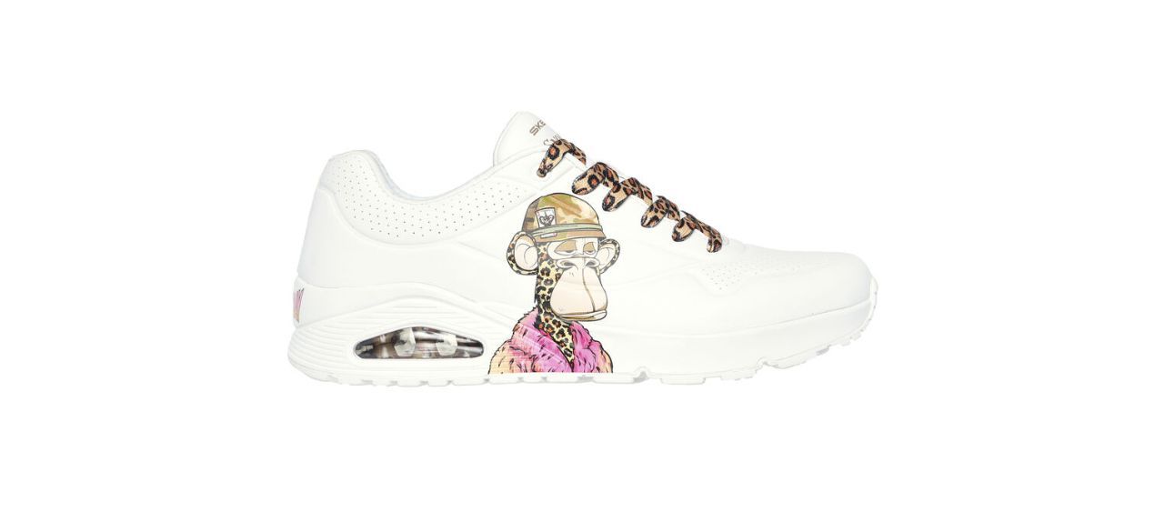 white leather sneakers with an image of Dr. Bombay (a cartoon monkey with cheetah skin wearing a beanie and a fluffy pink coat) on the side and beige cheetah-print laces