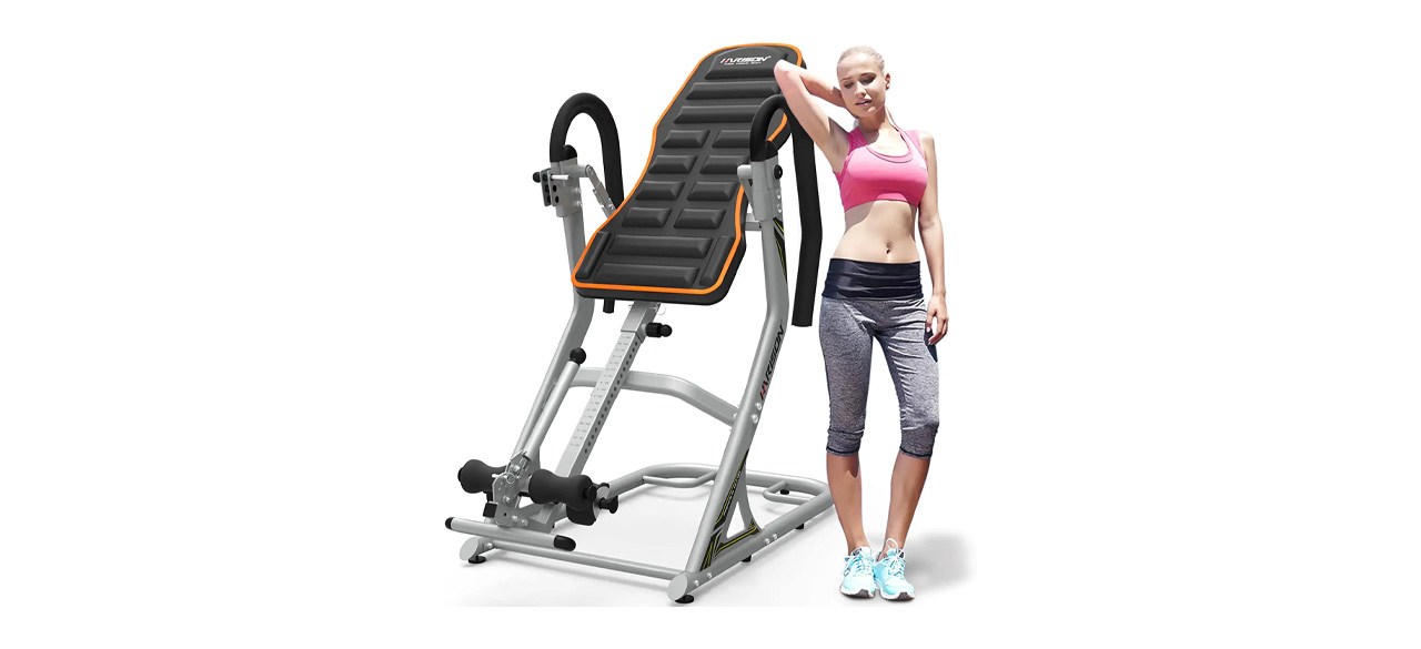 person standing next to a black and orange inversion table