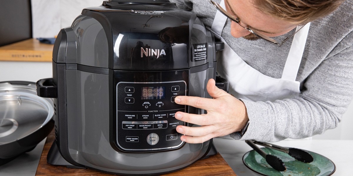 Person pressing buttons on Ninja Air Fryer control panel