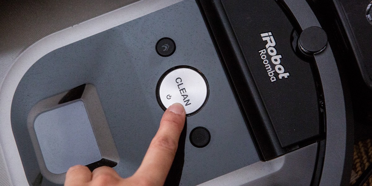 Finger on Roomba's "Clean" button