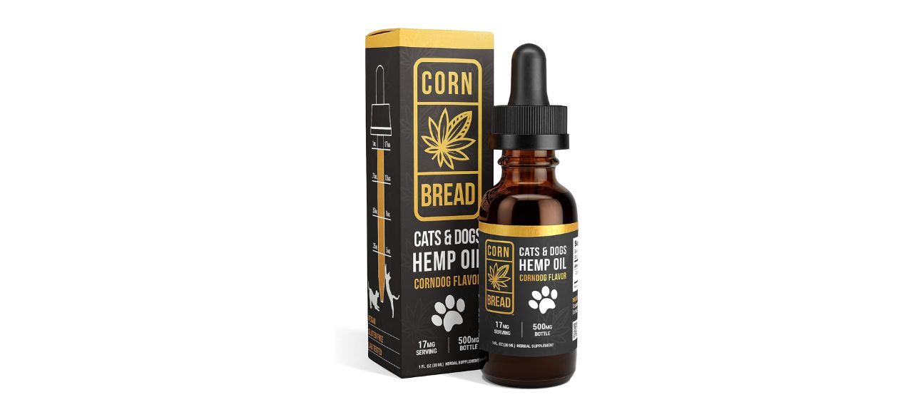 A rectangular box next to a small dropper bottle of CBD oil. Text on both reads: "Corn Bread Cats & Dogs Hemp Oil. Corndog flavor. 17mg serving. 500 mg bottle."